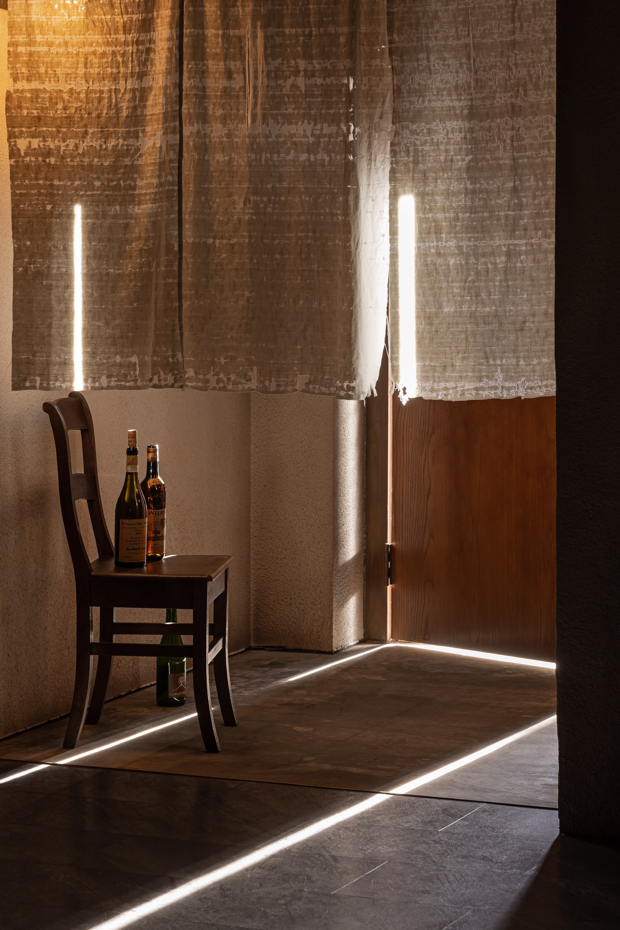 VDF Wine Bar|餐飲空間設計 — 光條掠過地面,白簾後的木椅與酒